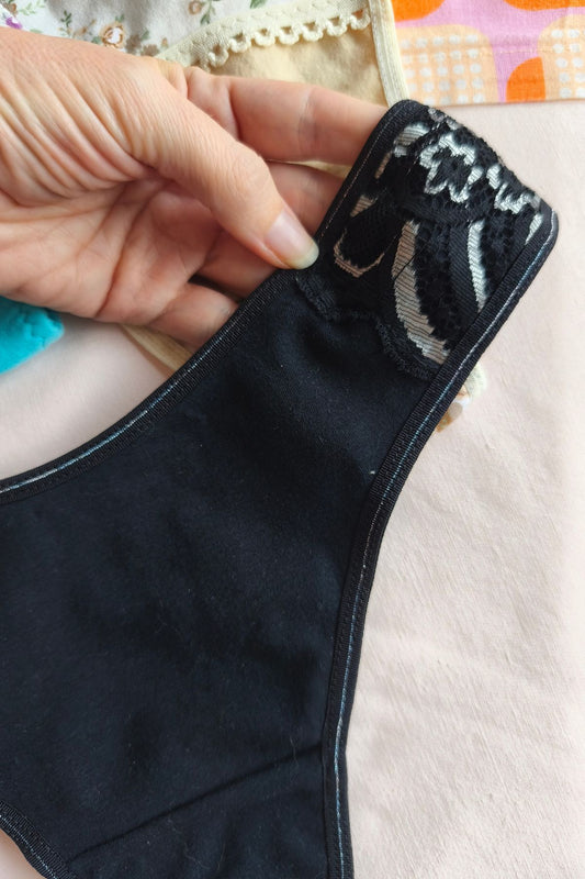 Detalle de puntilla negra y plata en bombacha vedetina algodón